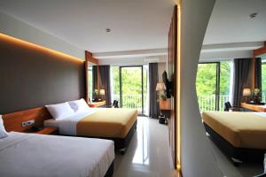 a hotel room with two beds and a balcony at Hay Bandung in Bandung