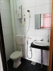 a bathroom with a toilet and a sink at Sri Gate Hotel in Dungun