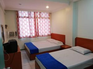 龙运Sri Gate Hotel的客房设有两张床、一台电视和一扇窗户。