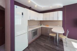 a kitchen with white cabinets and a table and chairs at Шахтеров, 74Б in Kemerovo