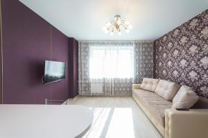 a living room with a couch and a tv at Шахтеров, 74Б in Kemerovo