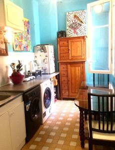 une cuisine avec un lave-linge et une table dans l'établissement Home Stay - Baie des Anges, à Nice