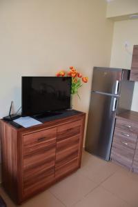 a kitchen with a tv on a wooden cabinet with a refrigerator at Pegaz Apartament in Świnoujście