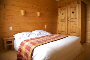 een slaapkamer met een bed in een houten kamer bij Les Arobiers in Lamoura