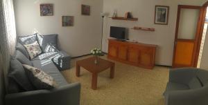 uma sala de estar com um sofá e uma televisão em Casa Carmela em Agaete
