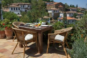 einen Tisch und Stühle auf einer Terrasse in der Unterkunft Terrace Houses Sirince in Selçuk