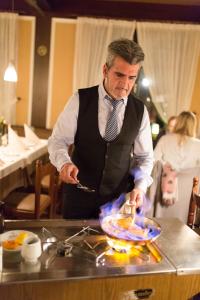 Un uomo in piedi in una cucina che prepara il cibo di SAN REMO Fine.Food.Hotel a Norimberga