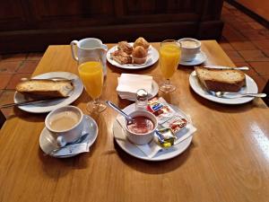 una mesa con platos de comida y vasos de zumo de naranja en La Posada de Don Mariano, en Pedraza-Segovia