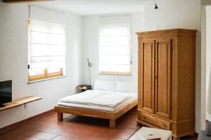 ラドルフツェル・アム・ボーデンゼーにあるFerienwohnung Design Apartment Seoulのベッドルーム1室(ベッド1台付)、木製キャビネットが備わります。