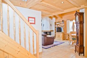una escalera de madera en una sala de estar con techo de madera en Apartment St. Louis 3.5 - GriwaRent AG, en Grindelwald