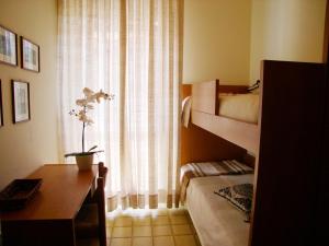 a bedroom with a desk and a bed and a window at Appartamento Saturnia in Grado