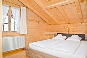 a bedroom with a large bed in a wooden room at Apartment St. Louis 3.5 - GriwaRent AG in Grindelwald