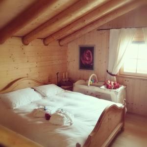 een slaapkamer met een bed met een teddybeer erop bij Baita del Nonno dei Pitoi in Bedollo