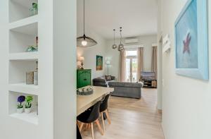 jadalnia i salon ze stołem i krzesłami w obiekcie Grande Casa 1926 w Chanii