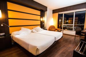 a hotel room with a large bed and a window at Hotel Abades Nevada Palace in Granada