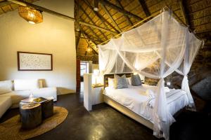 a bedroom with a bed with a canopy at Chacma Bush Camp in Balule Game Reserve