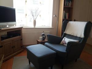 a living room with a chair and a television at Hedgehope Cottage Alnwick in Alnwick