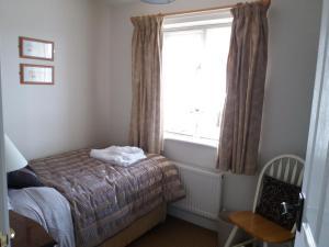 a small bedroom with a bed and a window at Hedgehope Cottage Alnwick in Alnwick