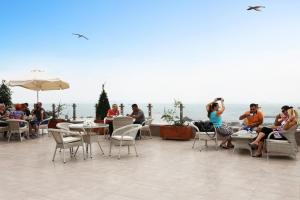 a group of people sitting at tables and chairs on a patio at Benler Otel Laleli ISTanbul in Istanbul