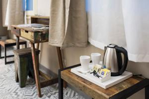 a table with a coffee pot and cups on it at TOHOUSE Rooms in Turin