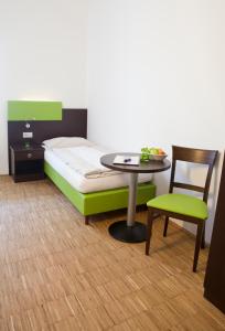 Zimmer mit einem Bett, einem Tisch und einem Stuhl in der Unterkunft Stadthotel Waidhofen an der Thaya in Waidhofen an der Thaya