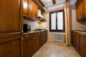 a large kitchen with wooden cabinets and a window at Red Fashion in Venice