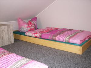 バート・シャンダウにあるWaldidylleのベッドルーム1室(ピンクと紫のシーツが備わるベッド1台付)