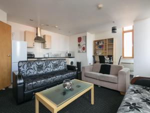 een woonkamer met een bank en een tafel bij Deluxe 2 Bed Apartment in Manchester