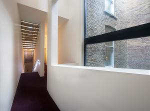 a hallway with a large window and a staircase at Nottingham Place Hotel in London