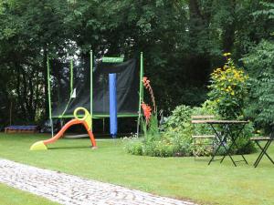 a playground in a garden with a table and a swing at Charming Apartment in Kr pelin with Barbecue in Kröpelin