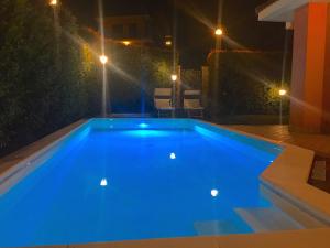 トレカスターニにあるBelvilla by OYO Villa Trecastagniの夜間の青いスイミングプール(照明付)