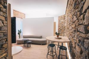 Zimmer mit einem Tisch, Stühlen und einer Steinmauer in der Unterkunft Moyua Apartment by People Rentals in Bilbao