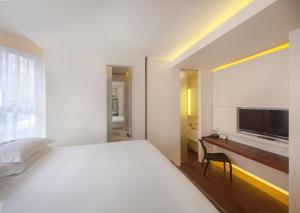 a white bedroom with a bed and a television at Nottingham Place Hotel in London