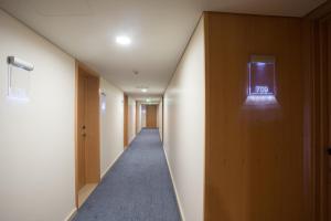 um longo corredor com uma luz na parede em Antillia Hotel em Ponta Delgada