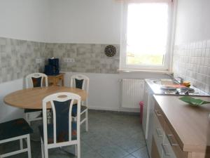 eine Küche mit einem Tisch, einem Tisch und Stühlen in der Unterkunft Ferienwohnungen und Zimmer in Nordhausen in Nordhausen