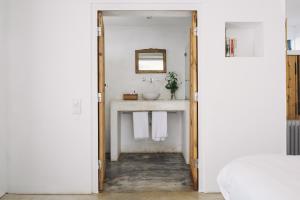 een badkamer met een wastafel en een spiegel bij Tres Marias in Vila Nova de Milfontes