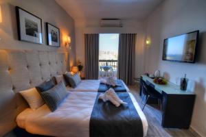 a living room with a large bed and a couch at St. Julian's Bay Hotel in St. Julianʼs