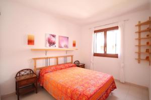 Schlafzimmer mit einem Bett und einem Fenster in der Unterkunft Apartment Carmen in L'Escala