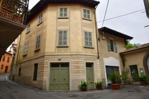 a building with green doors and windows on a street at Via Sambuco in Iseo