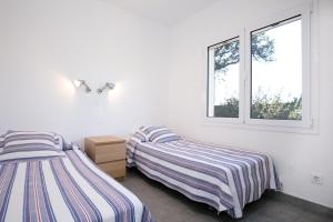 ロザスにあるCasa Almadravaの白い部屋 ベッド2台 窓付