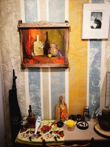 a table with a painting on the wall next to a painting at Rooster Hostel in Veliko Tŭrnovo