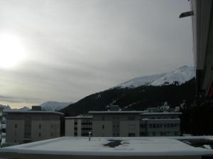 une ville enneigée sur les toits des bâtiments et des montagnes dans l'établissement Privatzimmer Erika Fasler, à Davos