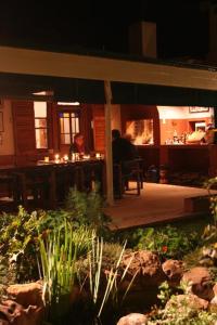 a person sitting at a table on a porch at night at Thyme and Again Bed and Breakfast in Graaff-Reinet