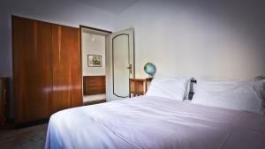 1 dormitorio con cama blanca y espejo en Casa della Vittoria en Maccagno Inferiore