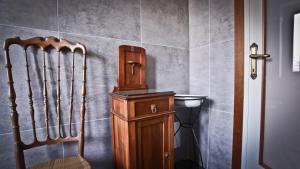 baño con armario de madera y silla en Casa della Vittoria, en Maccagno Inferiore