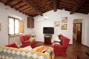 sala de estar con sillas rojas y TV en Pulcianese, en Corsano