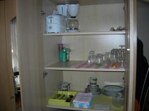 a cupboard with plates and glasses on it at Privatzimmer Erika Fasler in Davos