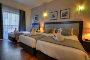 una habitación de hotel con dos camas con animales de peluche. en St. Julian's Bay Hotel, en San Julián
