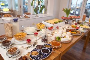 a buffet of food on a wooden table at Haus am Meer in Scharbeutz