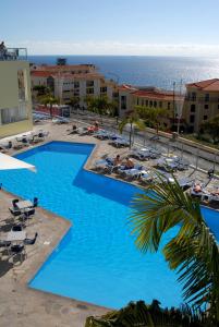 uma grande piscina com vista para o oceano em Muthu Raga Madeira Hotel no Funchal